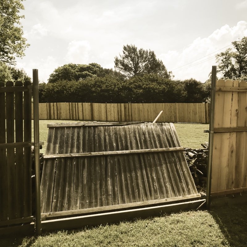 Filtered image collapsed wooden fence near new lumber